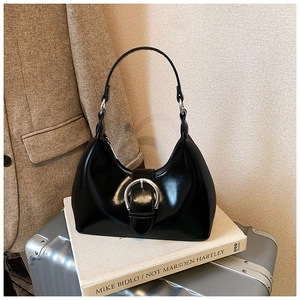 Détail du sac hobo noir avec boucle argentée dans un décor de bureau épuré
