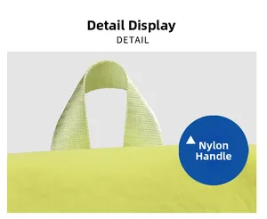 Detail view showing the durable nylon handle on the light green travel backpack
