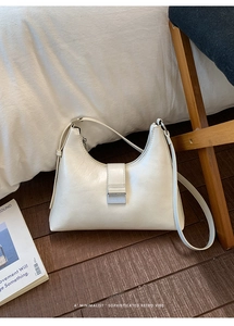 Detail of white Hobo shoulder bag featuring a silver rectangular metal lock and fine leather texture
