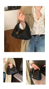 Dettaglio della borsa hobo nera a grana litchi con ciondolo a stella e finiture in metallo