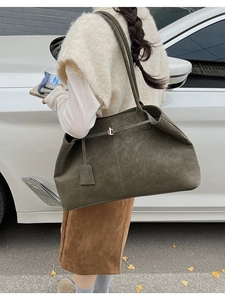 Détail du sac cabas en daim vert olive montrant la texture douce et la boucle en métal