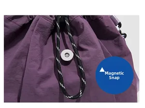 Detail of the magnetic snap closure and woven drawstring on the dark purple nylon backpack
