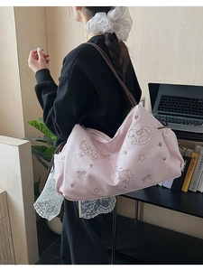 Pink faux leather tote bag with embroidery details and thin brown shoulder straps
