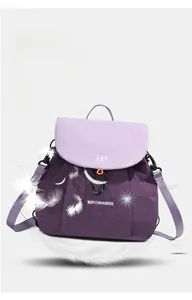 Detail shot of lightweight purple nylon backpack with flap closure and white feathers