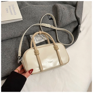 Vue détaillée du sac Boston crème avec lanières en cuir et bandoulière amovible réglable