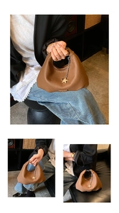 Dettaglio di una borsa hobo in pelle marrone con motivo litchi e ciondolo a stella