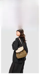 Detail view of stylish brown and beige outdoor messenger bag with a drawstring closure