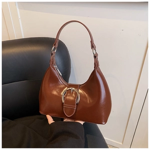 Détail du sac demi-lune marron rétro en cuir poli avec une grande boucle en métal argenté