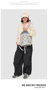 Détail d'un grand sac à dos de plein air avec coutures tricolores et cordes en X