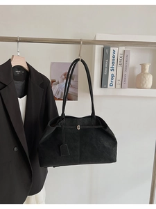 Gros plan sur un cabas en cuir mat noir rétro avec boucle dorée élégante en D