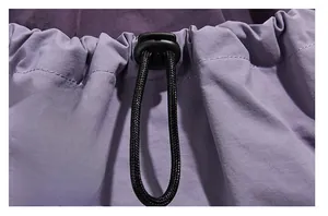 Detail of purple hiking backpack with black drawstring and adjustable plastic toggle