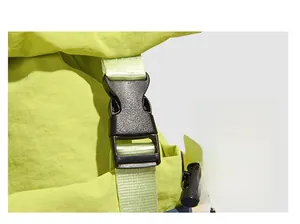 Close-up of durable black plastic buckle and nylon webbing on a green backpack