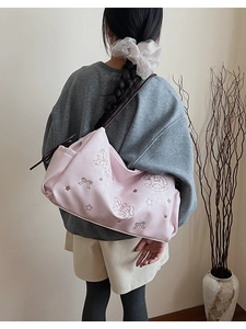 Pink tote bag with embroidered rocking horse and star details on shoulder
