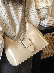 Sac demi-lune beige minimaliste en cuir verni brillant avec grande boucle argentée