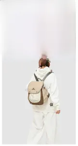 Detail view of khaki and brown vintage backpack with metal buckles and drawstring closure