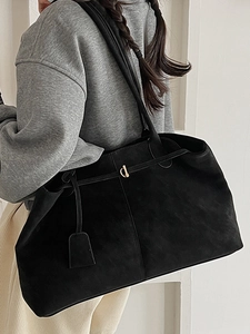 Grand sac cabas vintage en daim noir avec bandoulière porté par un mannequin de profil