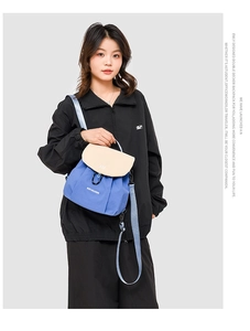Detail of a color-block mini backpack in royal blue and cream white with slim straps