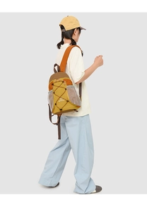 Détail du sac à dos extérieur avec patchwork jaune et orange et système de cordon élastique
