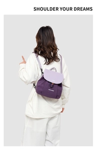 Detail view of mini purple contrast backpack with adjustable straps worn by a model