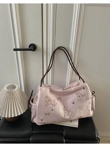 Detail of light pink tote bag with brown straps and cute cartoon horse prints