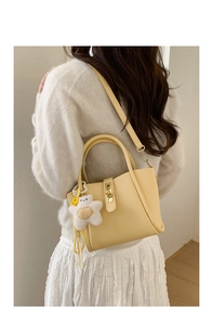 Dettaglio borsa beige in pelle martellata con chiusura dorata e ciondolo a stella
