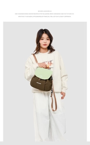Detail of a two-tone olive and green backpack worn by a model in a casual studio setting