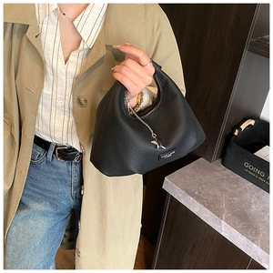 Dettaglio di una borsa hobo in pelle nera con ciondolo a stella argento e manico corto