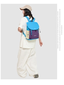 Detail view of multi-color drawstring backpack with sky blue flap and purple main compartment