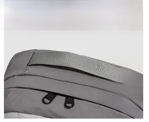Détail de la poignée robuste et de la double fermeture éclair du sac à dos gris