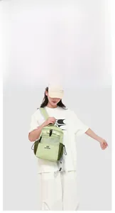 Detail view of water-resistant green outdoor backpack with side mesh pocket and brand logo