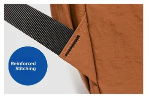 Close-up of reinforced bartack stitching on the brown outdoor backpack shoulder strap