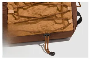 Close-up of adjustable brown elastic drawstring and plastic buckle on nylon backpack