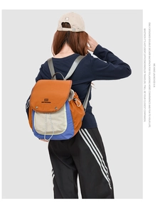 Model wearing a retro tricolor nylon backpack with adjustable side straps and drawstring
