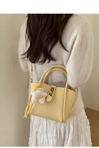 Dettaglio mini borsa in pelle gialla con ciondolo a stella in peluche bianco morbido
