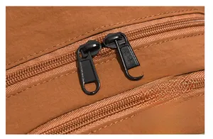 Detailed macro view of high-quality smooth black metal double zippers on brown backpack