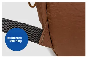 Detail showing the heavy-duty bartack reinforcement on the brown backpack strap