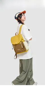 Side view of travel backpack with contrast colors and drawstring pockets on model