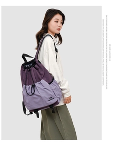 Side view of purple drawstring backpack showing nylon straps and hiking style layout