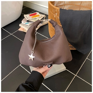 Dettaglio borsa hobo in pelle marrone con ciondolo a stella e accenti metallici argentati