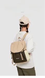 Detailed side view of the khaki and green nylon travel backpack on a female model