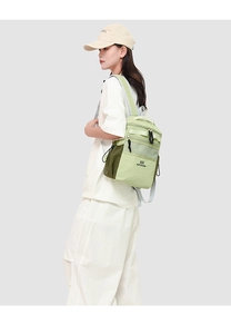 Outdoor light green water-resistant backpack shown on a model in a lifestyle setting