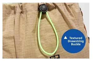 Close-up of textured khaki grid fabric with a black drawstring buckle and neon green cord