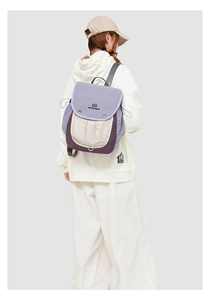 Rear view of model wearing a stylish color-block backpack with drawstring detail