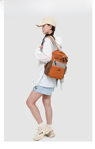Side view of lightweight orange and brown waterproof outdoor backpack on female model