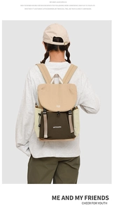 Detail of color-block backpack showing drawstring side pockets and adjustable straps