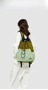 Detail view of the drawstring closure and durable olive green nylon fabric on the outdoor backpack