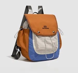 Detail view of colorful nylon backpack with orange flap and blue side pocket accents