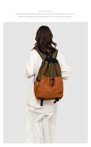 Detail of drawstring backpack in brown and orange featuring side handle and outer pocket