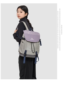 Détail d'un sac à dos multicolore montrant le nylon imperméable et la fermeture à cordon