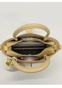 Vista dall'alto dell'interno della borsa a secchiello crema con smartphone e oggetti